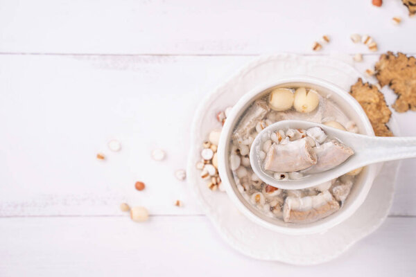 Tasty Four Tonics Herb Flavor Soup,Taiwanese traditional food with herbs,pork intestines on white wooden table,close up,flat lay,top view