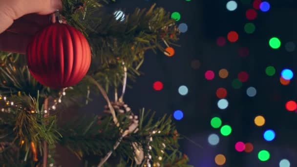 女の子は暗い黒の背景に輝くLedランプの照明スポットで ショットを閉じ クリスマスツリー上のクリスマスの装飾を飾るぶら下がっている — ストック動画