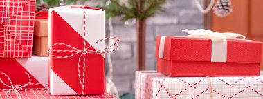 Güzel kırmızı ve beyaz hediyelerle süslenmiş Noel ağacı. Siyah tuğla duvarlı, şenlikli tasarım konsepti. Yakın çekim..