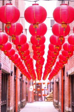 Beautiful round red lantern hanging on old traditional street, concept of Chinese lunar new year festival, close up. The undering word means blessing. clipart