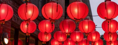 Beautiful round red lantern hanging on old traditional street, concept of Chinese lunar new year festival, close up. The undering word means blessing. clipart