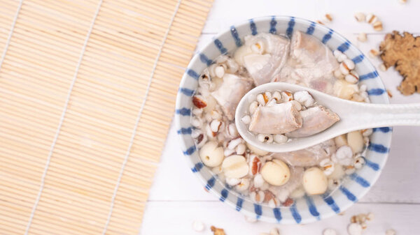 Tasty Four Tonics Herb Flavor Soup, Taiwanese traditional food with herbs, pork intestines on white wooden table, close up, flat lay, top view.