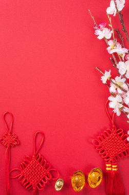 Çin 'in Yeni Yıl Tasarım Konsepti - Kırmızı arka planda izole edilmiş erik çiçeği olan güzel Çin düğümü, düz konum, üst manzara, genel görünüm.