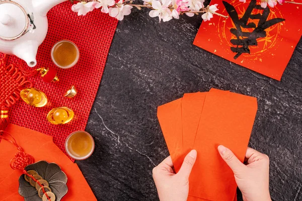 Concepto de diseño del año nuevo lunar chino de enero: mujer sosteniendo, dando sobres rojos (ang pow, hong bao) por dinero de la suerte, vista superior, posición plana, arriba. La palabra 'chun' significa primavera que viene . — Foto de Stock