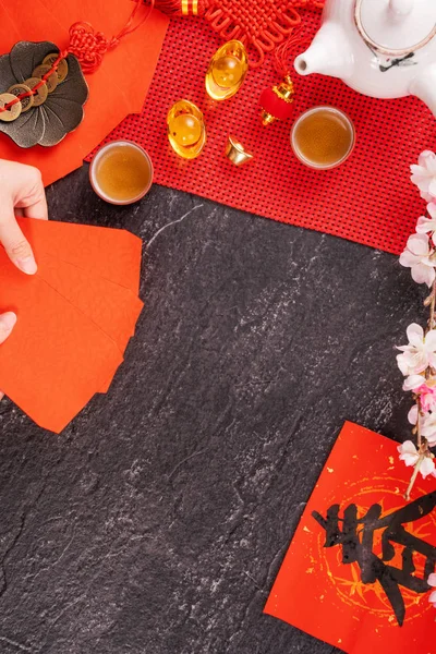 Concepto de diseño del año nuevo lunar chino de enero: mujer sosteniendo, dando sobres rojos (ang pow, hong bao) por dinero de la suerte, vista superior, posición plana, arriba. La palabra 'chun' significa primavera que viene . — Foto de Stock