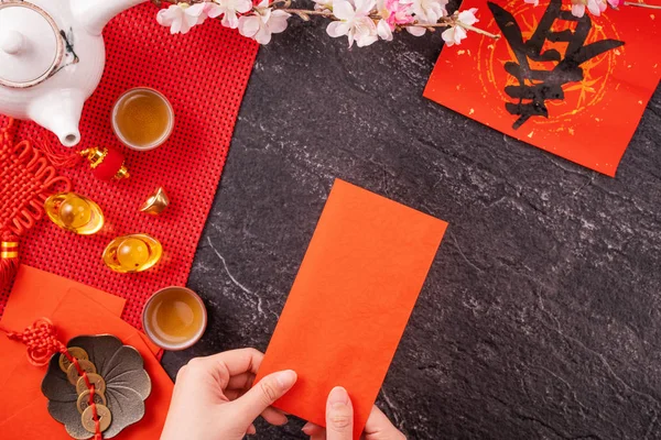 Concepto de diseño del año nuevo lunar chino de enero: mujer sosteniendo, dando sobres rojos (ang pow, hong bao) por dinero de la suerte, vista superior, posición plana, arriba. La palabra 'chun' significa primavera que viene . — Foto de Stock