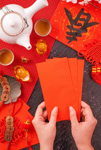 Concepto de diseño del año nuevo lunar chino de enero: mujer sosteniendo, dando sobres rojos (ang pow, hong bao) por dinero de la suerte, vista superior, posición plana, arriba. La palabra 'chun' significa primavera que viene . — Foto de Stock