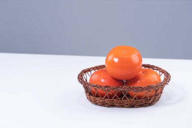 Gri mavi arka planı olan beyaz mutfak masasında izole edilmiş taze, dilimlenmiş tatlı hurma hurması, Çin 'in yeni yıl tasarım konsepti, yakın plan..