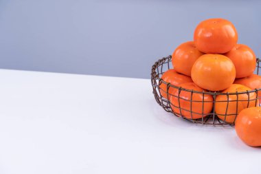 Gri mavi arka planı olan beyaz mutfak masasında izole edilmiş taze, dilimlenmiş tatlı hurma hurması, Çin 'in yeni yıl tasarım konsepti, yakın plan..