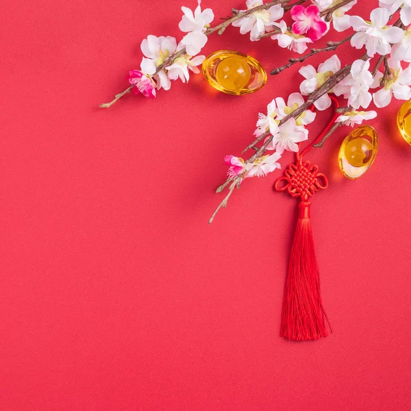 Concepto de diseño de año nuevo lunar chino Hermoso nudo chino con flor de ciruelo aislado sobre fondo rojo, plano laico, vista superior, diseño de arriba . — Foto de Stock