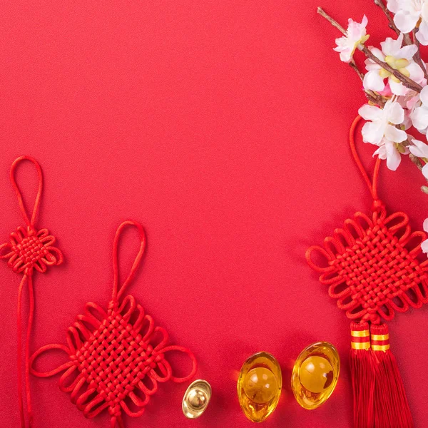 Concepto de diseño de año nuevo lunar chino Hermoso nudo chino con flor de ciruelo aislado sobre fondo rojo, plano laico, vista superior, diseño de arriba . — Foto de Stock
