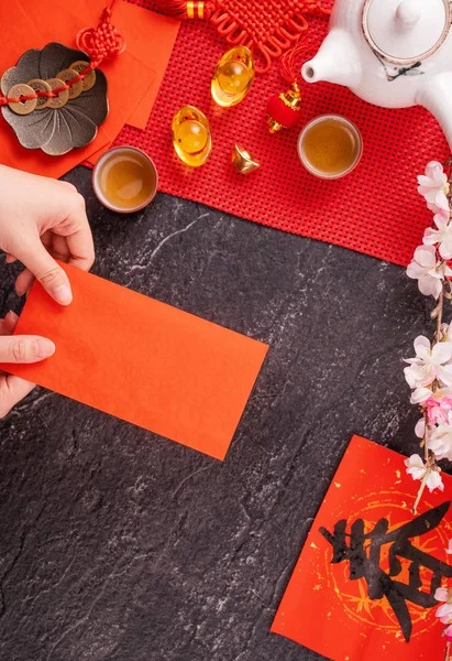 Concepto de diseño del año nuevo lunar chino de enero: mujer sosteniendo, dando sobres rojos (ang pow, hong bao) por dinero de la suerte, vista superior, posición plana, arriba. La palabra 'chun' significa primavera que viene . — Foto de Stock