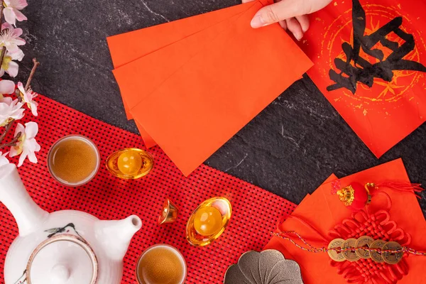 Concepto de diseño del año nuevo lunar chino de enero: mujer sosteniendo, dando sobres rojos (ang pow, hong bao) por dinero de la suerte, vista superior, posición plana, arriba. La palabra 'chun' significa primavera que viene . — Foto de Stock