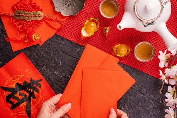 Concepto de diseño del año nuevo lunar chino de enero: mujer sosteniendo, dando sobres rojos (ang pow, hong bao) por dinero de la suerte, vista superior, posición plana, arriba. La palabra 'chun' significa primavera que viene . — Foto de Stock