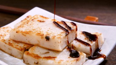 Lezzetli şalgam kekinin üzerine kara soya sosu dök restoranda geleneksel Çin turplu keki, kapat, uzayı kopyala.