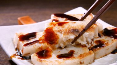 Lezzetli şalgam kekinin üzerine kara soya sosu dök restoranda geleneksel Çin turplu keki, kapat, uzayı kopyala.