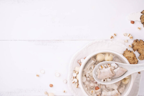 Tasty Four Tonics Herb Flavor Soup,Taiwanese traditional food with herbs,pork intestines on white wooden table,close up,flat lay,top view