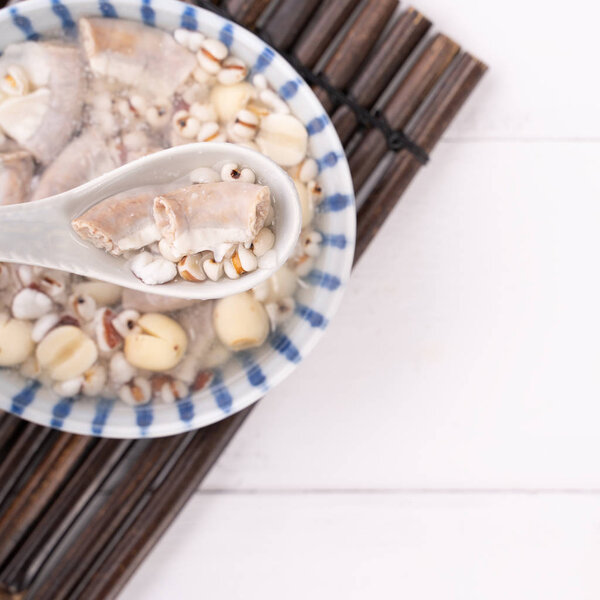Tasty Four Tonics Herb Flavor Soup,Taiwanese traditional food with herbs,pork intestines on white wooden table,close up,flat lay,top view