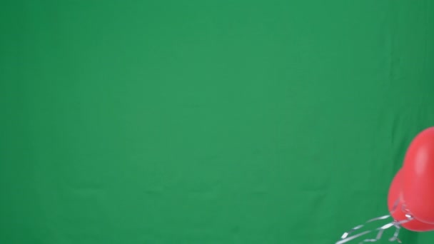緑の画面の背景に隔離された赤いハート型のヘリウム気球 バレンタインデー 誕生日パーティーのデザインコンセプト スタジオショット — ストック動画