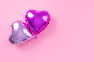 Sevgililer Günü asgari tasarım konsepti - soluk pembe arka planda izole güzel kalp şeklinde folyo balon, üst görünüm, düz yatış, yukarıdaki fotoğrafçılık.