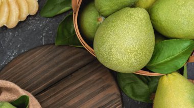 Taze soyulmuş pomelo, pummelo, greyfurt, bambu sepetinde koyu arka planda Shaddock. Sonbahar mevsimlik meyveler, üst manzara, düz yatış, masa üstü çekimi.