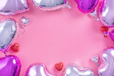 Sevgililer Günü romantik tasarım konsepti soluk pembe arka planda izole edilmiş güzel bir kalp şeklinde folyo balonu, düz bir görünüm, yukarıdaki fotoğrafçılık..