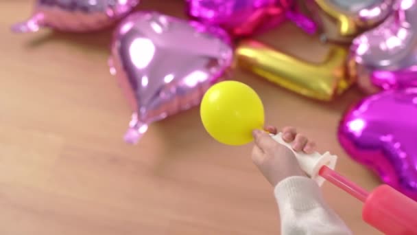 女人正在人工抽吸空气到形状的气球里 准备在家里用充气器 生活方式装饰节日派对 — 图库视频影像