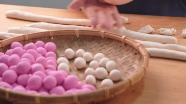 Asya 'dan bir kız Tang yuan, yuan xiao, Çin geleneksel yemek pirinç köftelerini yeni yıl ve kış festivali için kırmızı ve beyaz yapıyor..