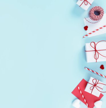 Sevgililer günü, anneler günü sanat tasarım konsepti kırmızı, beyaz paketlenmiş hediye kutusu pastel rengi açık mavi arka plan, düz alan, üst manzara.