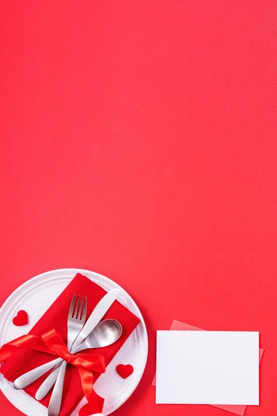 Valentine\'s Day meal design concept - Romantic plate dish set isolated on red background for restaurant, holiday celebration promotion, top view, flat lay.