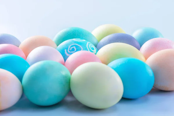 Colorful Easter eggs dyed by colored water isolated on a pale blue background, design concept of Easter holiday activity, close up, copy space. — Stock Photo, Image