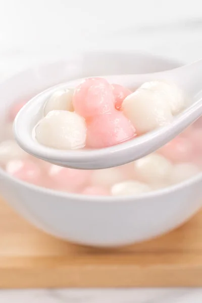 Tang yuan, tangyuan, bola pangsit nasi merah dan putih yang lezat dalam mangkuk kecil. Makanan tradisional Asia untuk Festival Solstice Musim Dingin Cina, tutup . — Stok Foto