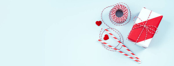 Valentine's Day, Mother's day handmade gift design concept - Wrapped gift box isolated on pastel light blue color background, flat lay, top view.