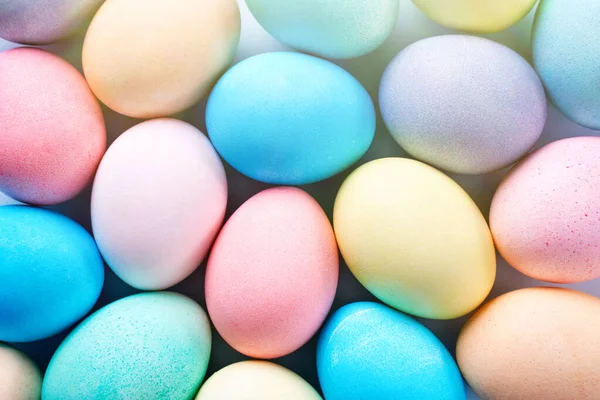 Színes húsvéti tojások festett színes vízzel, gyönyörű mintával, halványkék háttér, tervezési koncepció az ünnepi tevékenység, felülnézet, teljes keret. — Stock Fotó