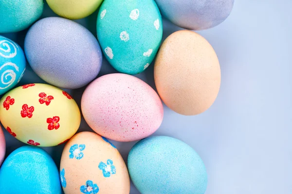 Renkli Paskalya yumurtaları. Renkli suyla boyanmış. Soluk mavi arka planda güzel desenli.. — Stok fotoğraf