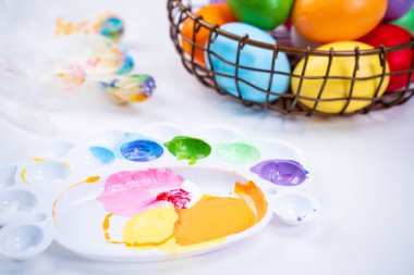 Tasarım konsepti - Paskalya kutlaması için hazırlanmak, Paskalya yumurtalarını renkli akrilik pigmentlerle boyamak, palette renkli şeyler, yakın plan, yaşam tarzı.