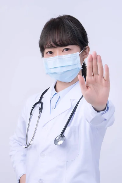 年轻的女医生 戴着面具 做停止手势 说没有白色背景的隔离 拒绝病毒性疾病 — 图库照片