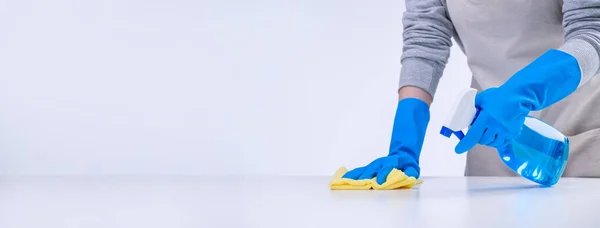 年轻的女管家正在用蓝色手套 喷雾清洁剂 湿黄色抹布 复制空间 空白设计理念等清洗围裙中的白桌 — 图库照片