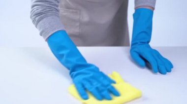 Genç bayan temizlikçi önlüklü beyaz masa temizliyor mavi eldivenli, sprey temizleyicili, ıslak sarı paçavralı, yakın plan, fotokopi alanı, boş tasarım konsepti..
