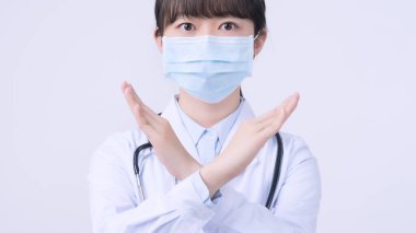 Maske takan genç bayan doktor, dur işareti yapıyor, işaret veriyor, beyaz arka planda izole edilmemiş, virüs hastalığını reddeden, kapat, boş.