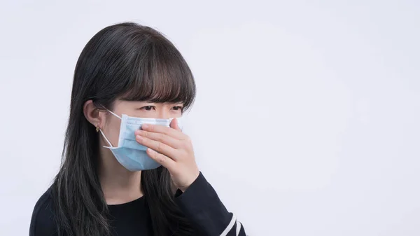 戴口罩的女人咳嗽 年轻的亚洲人捂着嘴 戴着医疗用的蓝色口罩感觉不适 被白色背景隔离 — 图库照片