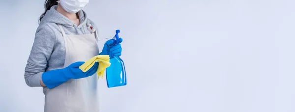 穿着围裙的年轻女管家正在用蓝色手套 湿黄色抹布 喷雾器清洁剂 复制空间 空白设计理念进行清洁 — 图库照片