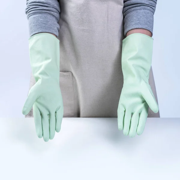 年轻的女管家身穿围裙 戴着绿色手套来清洁餐桌 概念是防止感染白色背景的病毒 近距离接触 — 图库照片