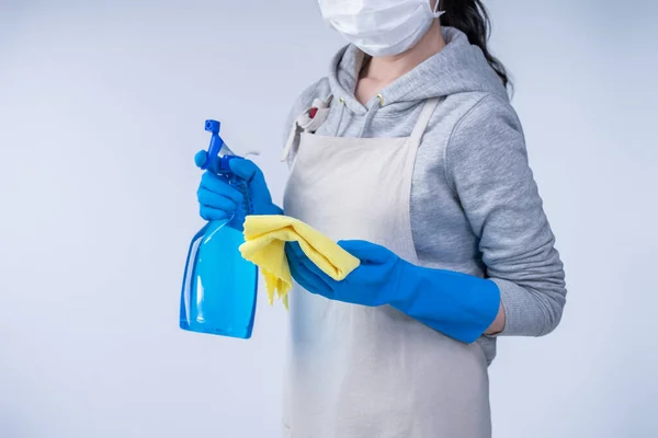 穿着围裙的年轻女管家正在用蓝色手套 湿黄色抹布 喷雾器清洁剂 复制空间 空白设计理念进行清洁 — 图库照片
