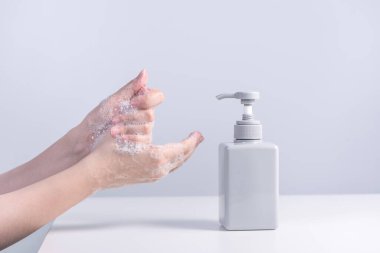 Yıkama eli. Asyalı genç kadın ellerini yıkamak için sıvı sabun kullanıyor, hijyen kavramı beyaz arka planda izole edilmiş koronavirüsü yaymayı durdurmak için, yakın plan.