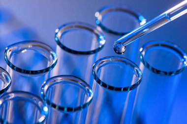 Test tüpü sırası. Tıbbi ya da bilim laboratuarı kavramı, mavi tonlu damlacıklı sıvı damlası, yakın plan, mikro fotoğrafçılık resmi.