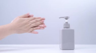 El yıkama talimatları. Asyalı genç bir kadın ellerini yıkamak için sıvı sabun kullanıyor. Beyaz arka planda izole edilmiş koronavirüs yaymayı durdurmak için hijyen kavramı..