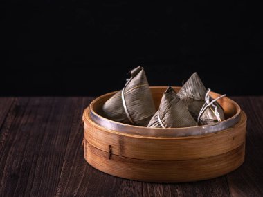 Zongzi - Çin pirinçli zongzi hamur tatlısı ahşap masa üzerinde siyah arka plan Ejderha Teknesi Festivali kutlamaları için, kapatın, kopyalayın.