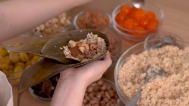 Zongzi yapmak - aile yemeği hazırlamak Çin pirinçli zongzi hamur tatlısı evde ahşap masa üzerinde Ejderha Teknesi Festivali için bir araya gelmek, kapanış, yaşam tarzı.