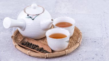 Beyaz çaydanlıkta sıcak çay ve parlak gri çimento arka plan üzerinde elek, yakın plan, uzay tasarımı konseptini kopyala.